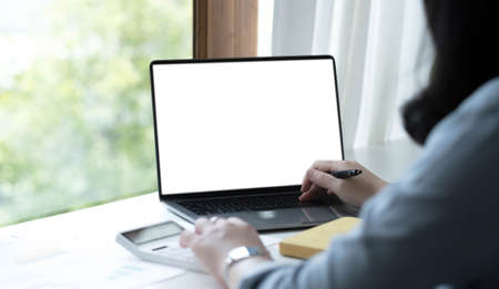 Business women work with calculator and laptop,pen and notebook on the wooden table