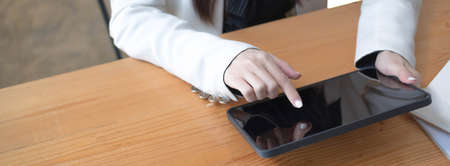 Cropped shot of woman hand using calculator while sitting at office desk, vertical view.
