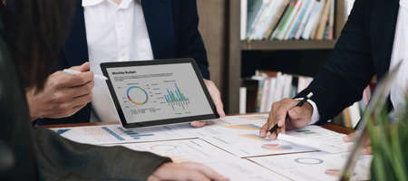 Business team analyzing income charts and graphs with modern laptop computer. Close up.Business...