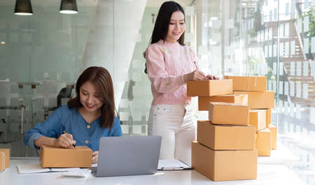 Portrait of Starting small businesses SME owners, two Asian woman check online orders Selling...