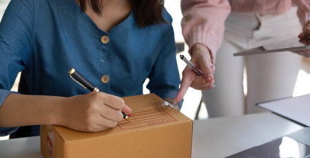 Portrait of Starting small businesses SME owners, two Asian woman check online orders Selling...