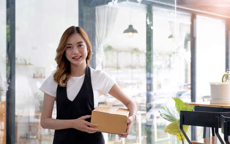 Attractive beautiful young Asian female restaurant or coffee shop waitress noting a customer's order...