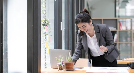 Portrait of a beautiful smiling woman using a mobile phone outdoorsの写真素材