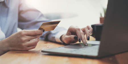 Hands holding credit card and using mobile smart phone with morning, Online shopping.の写真素材