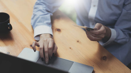 Hands holding credit card and using mobile smart phone with morning, Online shopping.の写真素材