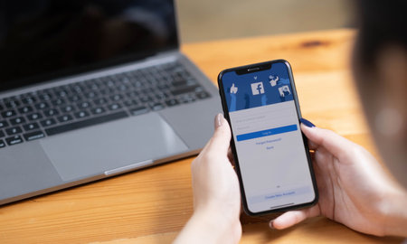 CHIANG MAI ,THAILAND - AUG 18, 2022 : Woman hand holding iPhone X to use facebook with new login...