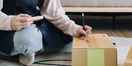 Portrait of Starting small businesses owners female entrepreneurs working on receipt box and check online orders to prepare to pack the boxes, sell to customers, sme business ideas online.の写真素材