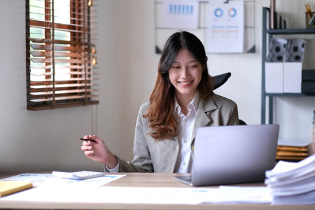 Portrait of smiling beautiful business asian woman working in office use computer with copy space.の写真素材