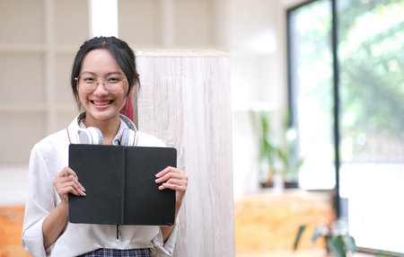 Beautiful Asian woman barista wearing an apron at the cafÃ© owner holding the tablet. Looking at...