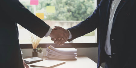 Two confident business man shaking hands during a meeting in the office, success, dealing, greeting and partner concept.の写真素材