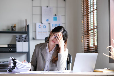 Asian businesswoman gets stressed while having a problem at work in the office.の写真素材