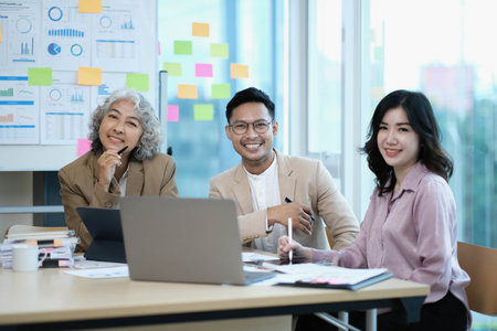 Group of Asia young creative people in smart casual wear smiling in creative office workplace....