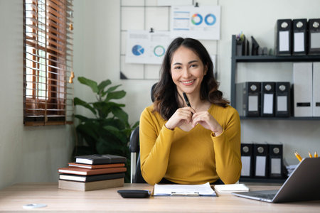 Asian businesswoman meeting at the office, taking notes and using a tablet at the office.の写真素材
