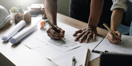 Team construction engineers working at construction site with blueprint on table