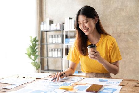 Young asian designer woman drawing a website outline and website ux app development on mobile phone.の写真素材