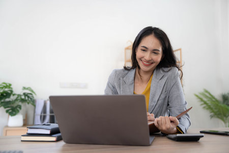 Portrait of an Asian young business Female working on a laptop computer in her workstation.Business people employee freelance online report marketing concept.の写真素材