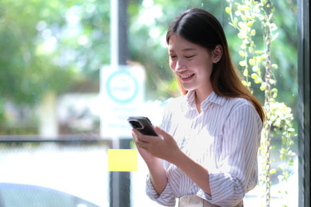 Portrait of elegant successful asian business woman speaking by smartphone and smiling happily while...