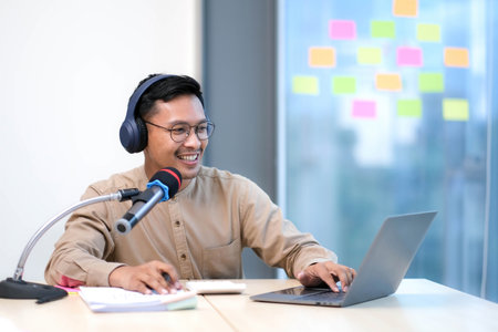 Young man recording podcast using microphone and laptop happy face smiling Positive person.