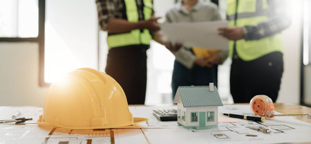 Civil engineer teams meeting working together wear worker helmets hardhat on construction site in...