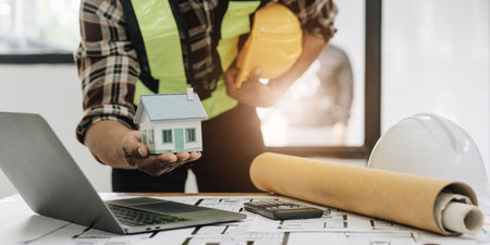 Close up of civil male engineer asian working on blueprint architectural project at construction...