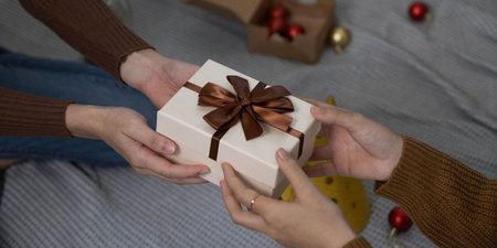 Happy woman giving Christmas and New Year Gift box to woman at Home.Family Xmas celebration....