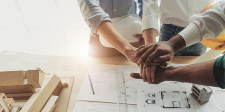 Businessmen and engineers join hands to build successful projects. Teamwork concept.の写真素材