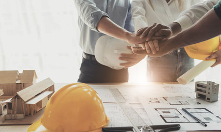 Businessmen and engineers join hands to build successful projects. Teamwork concept.の写真素材