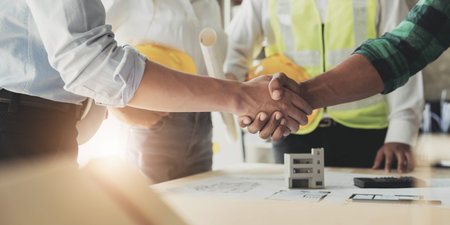 Professional Asian male engineer shaking hands with male architect after the meeting