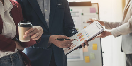 Businessman holding pens and holding graph paper are meeting to plan sales to meet targets set in...