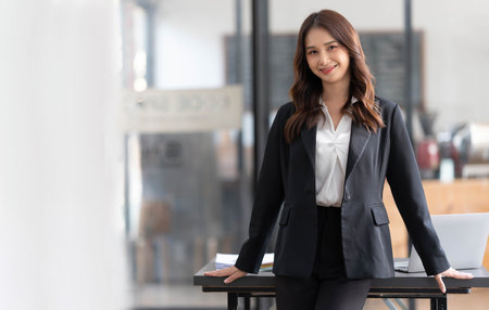 Charming Young Asian businesswoman standing in the office. Looking at camera.の写真素材