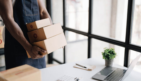 Start up entrepreneur of young asian man working with box for packaging order from shopping online...