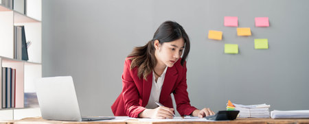 Business woman using calculator for do math finance on wooden desk in office and business working background, tax, accounting, statistics and analytic research concept.の写真素材