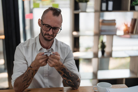Stressed caucasian man breaking his credit, card bankruptcy, financial problems conceptの写真素材