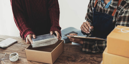 Young asian people couple Male and female small business owner checking online orders and packing...
