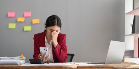 Sad young woman working at home office and brainstorming herself writing down on paper. Dissatisfied businesswoman crumples throwing the written-off sheets of paper with bad ideas and mistakes. Crisisの写真素材