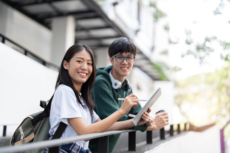 Group of Asian college student reading books and tutoring special class for exam on grass field at outdoors. Happiness and Education learning concept. Back to school concept. Teen and people theme.の写真素材