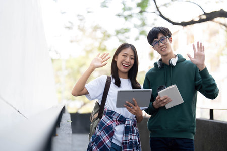 Group of Asian college student reading books and tutoring special class for exam on grass field at outdoors. Happiness and Education learning concept. Back to school concept. Teen and people theme.の写真素材