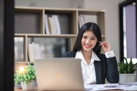 Business woman using calculator for do math finance on wooden desk in office and business working background, tax, accounting, statistics and analytic research concept.の写真素材