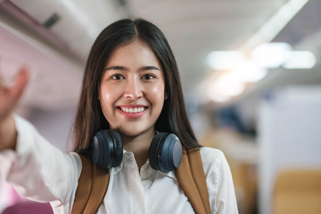Portrait of an Asian woman taking a selfie or capturing memories while waiting for an economy class flight. Travel concept, vacations, tourismの写真素材