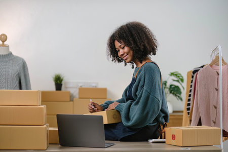 Startup small business entrepreneur SME, asian woman packing cloth in box. Portrait young Asian small business owner home office, online sell marketing delivery, SME e-commerce telemarketing concept.の写真素材