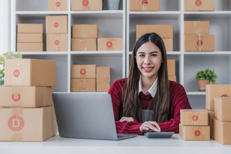 Startup small business entrepreneur SME, asian woman packing cloth in box. Portrait young Asian small business owner home office, online sell marketing delivery, SME e-commerce telemarketing concept.の写真素材