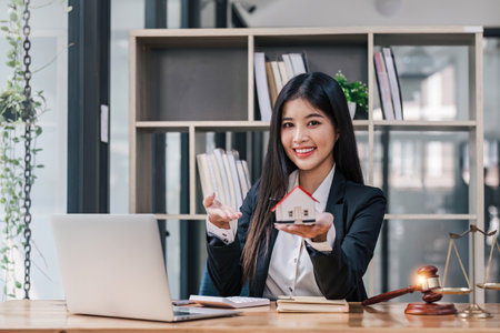 Real estate concept, businessman holding a house icon. House on Hand.Property insurance and security concept. Protecting gesture of female and symbol of house..の写真素材