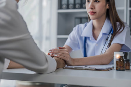 female doctor hold hand of caucasian woman patient give comfort, express health care sympathy, medical help trust support encourage reassure infertile patient at medical visit, closeup view.の写真素材