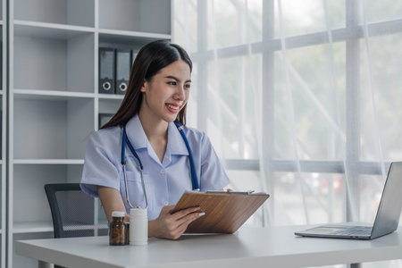 Portrait of smiling young Caucasian female doctor or nurse in white medical uniform in clinicの写真素材