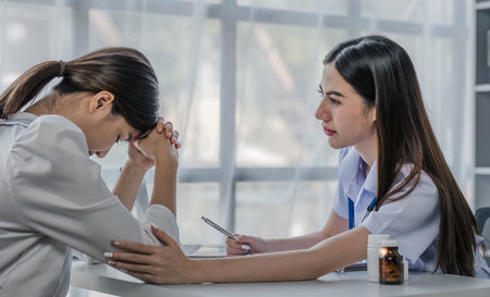 Nurse talking with a nursing home patient about his health. The nurse is making notes on a digital tabletの写真素材
