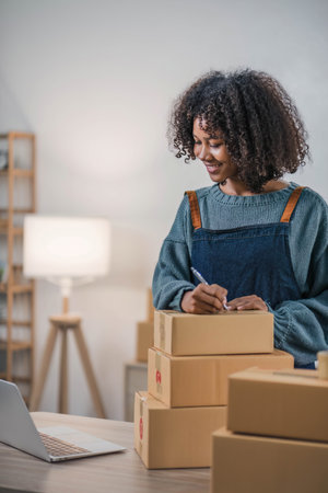 Startup small business entrepreneur SME, asian woman packing cloth in box. Portrait young Asian small business owner home office, online sell marketing delivery, SME e-commerce telemarketing concept.の写真素材