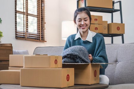 Portrait young attractive asian female owner startup business work happy with box at home prepare...