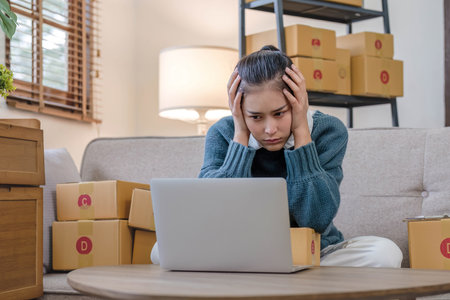Young Asian woman entrepreneurs stress with finance problems after sales decline because of economic...