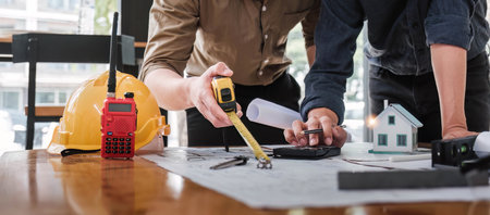Civil engineer teams meeting working together wear worker helmets hardhat on construction site in...