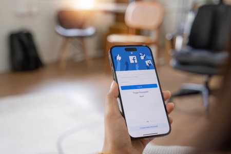 CHIANG MAI, THAILAND - MAY 1, 2023: Facebook social media app logo on log-in, sign-up registration page on mobile app screen on iPhone 14 in persons hand working on e-commerce shopping businessのeditorial素材